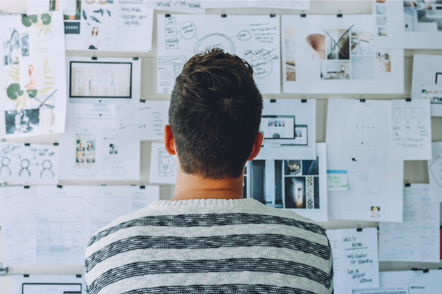 A person standing in front of a wall covered with papers