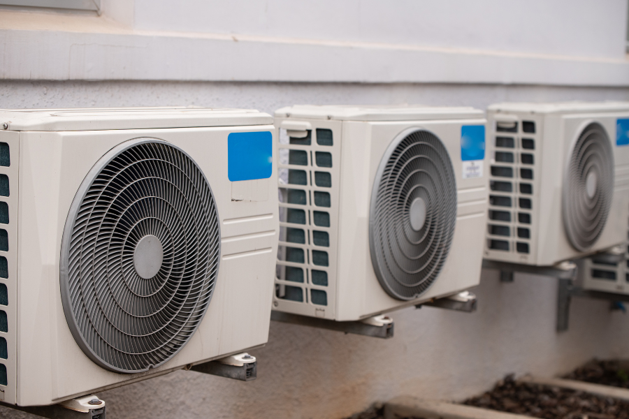 several air conditioners are lined up on the side of a building