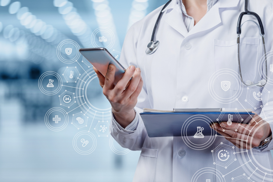 A doctor in a white lab coat is holding a tablet with icons on it