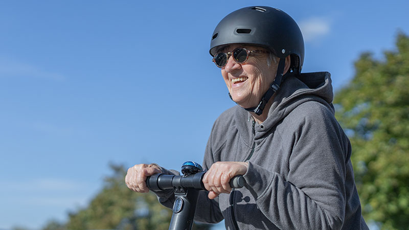 A person wearing a helmet on an electric scooter