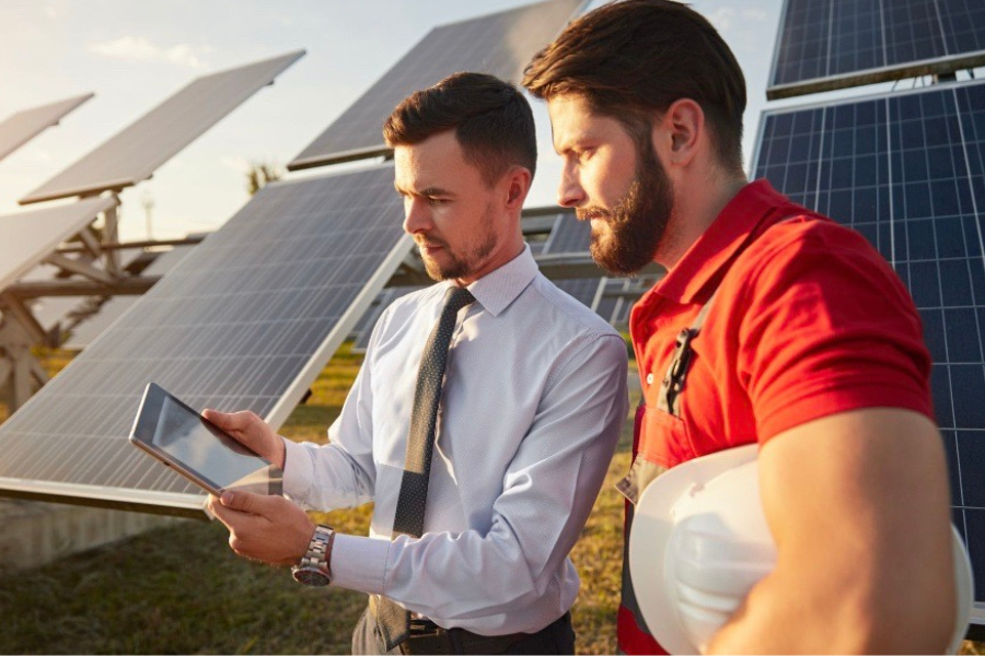 Two people standing in front of solar panels