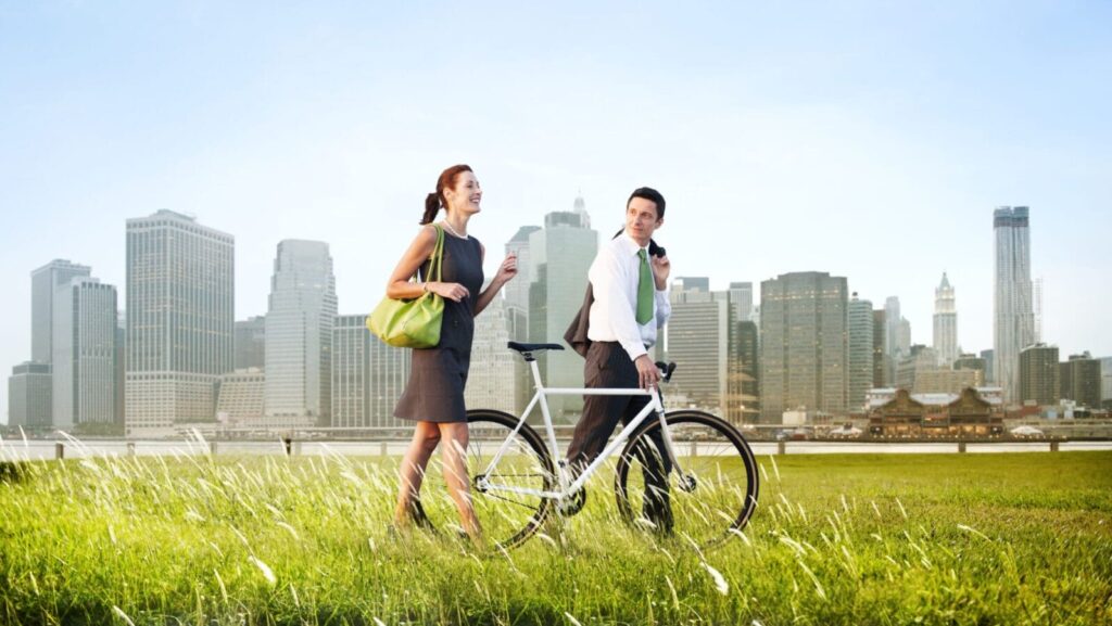 Two people standing in a field with a bicycle